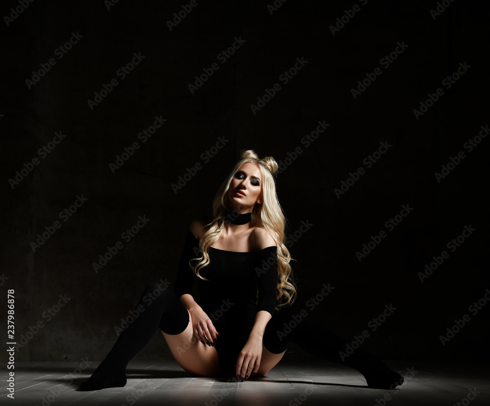 Young sexy blonde fashion woman sitting on floor in black body cloth and choker Young sexy blonde fashion woman sitting on floor in black body cloth and choker