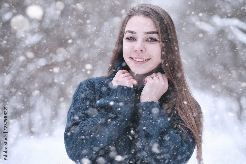 Girl in a winter park in snowfall Girl in a winter park in snowfall