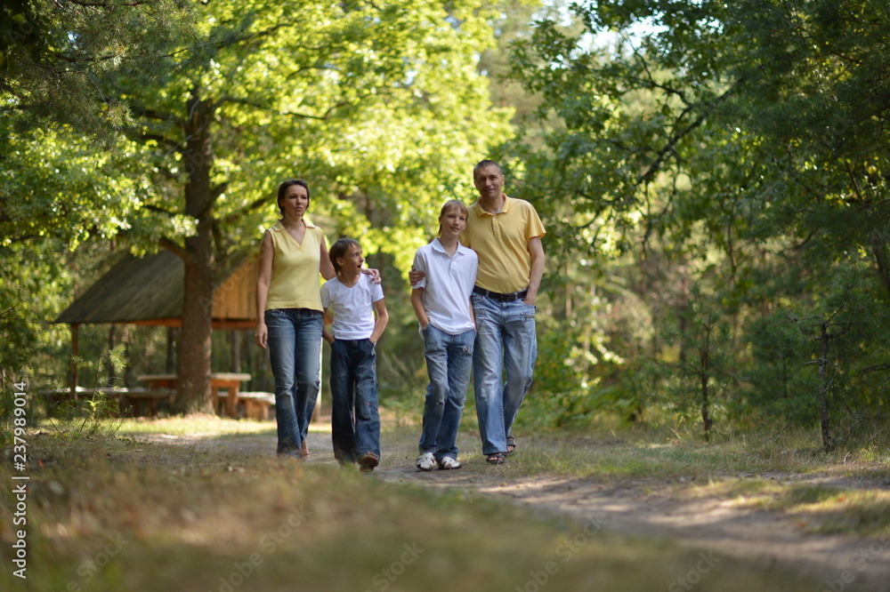 Portrait of happy family of four in autumn park walking