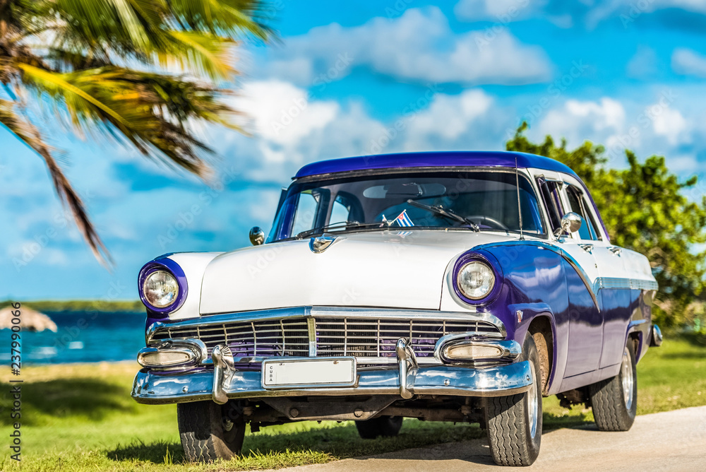 HDR - Blau weißer amerikanischer Oldtimer parkt am Strand auf dem Malecon nahe des Strandes in Havana Cuba - Serie Cuba Reportage