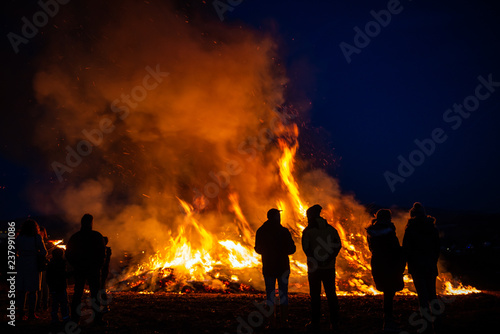 silhouettes of people in frontof big fire