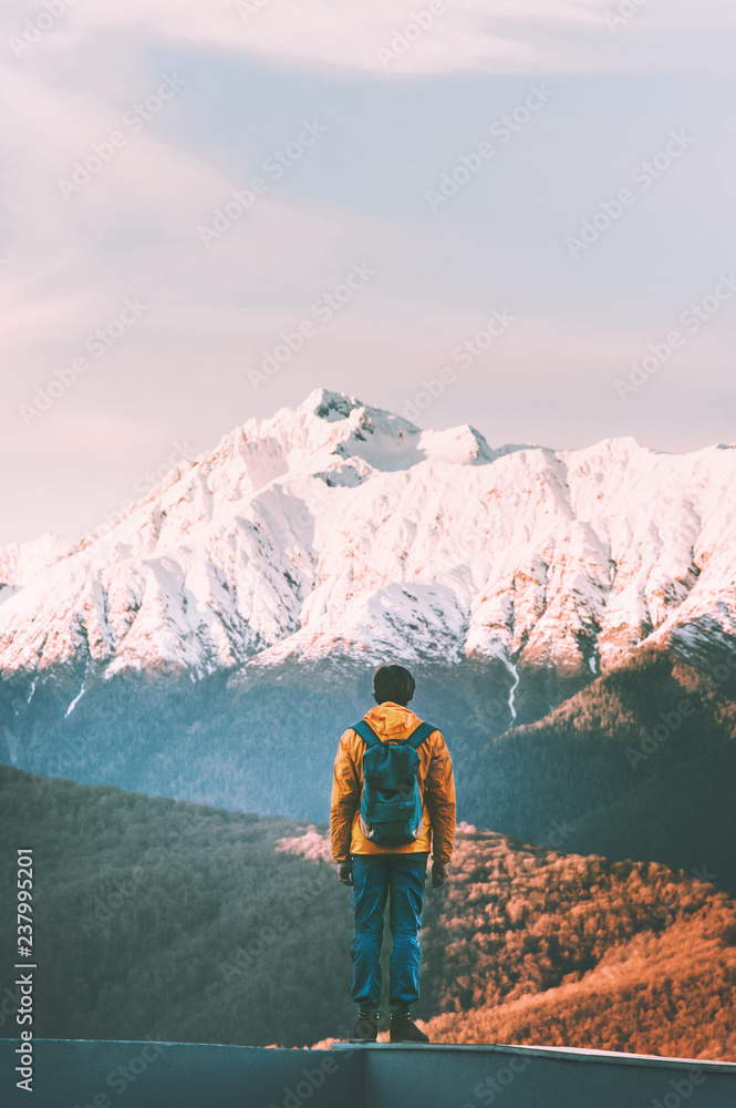 Man traveler walking alone in sunset mountains active lifestyle winter vacations outdoor hiking adventure solitude and silence