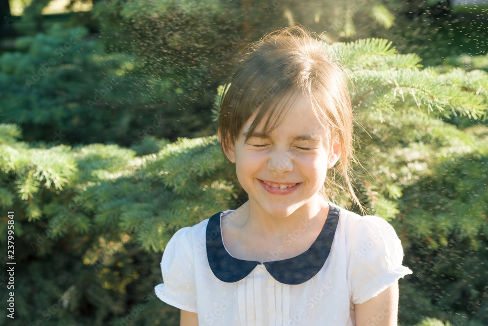 Happy little girl with closed eyes in spray of thermal water drops on hot summer day in the park Happy little girl with closed eyes in spray of thermal water drops on hot summer day in the park