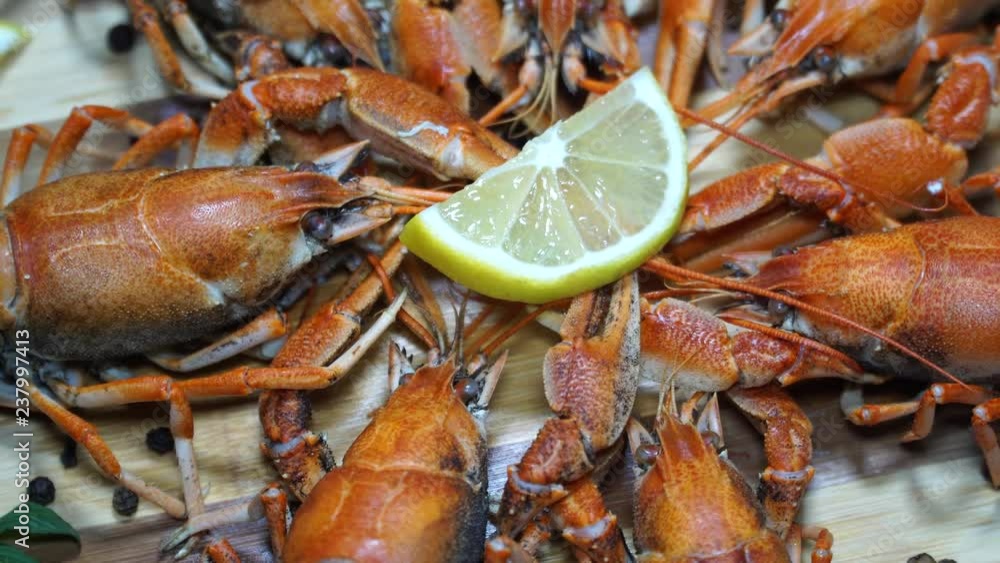 Freshly cooked hot crayfish ready to eat. River crayfish with lemon rotating on wooden table. 4K Freshly cooked hot crayfish ready to eat. River crayfish with lemon rotating on wooden table. 4K
