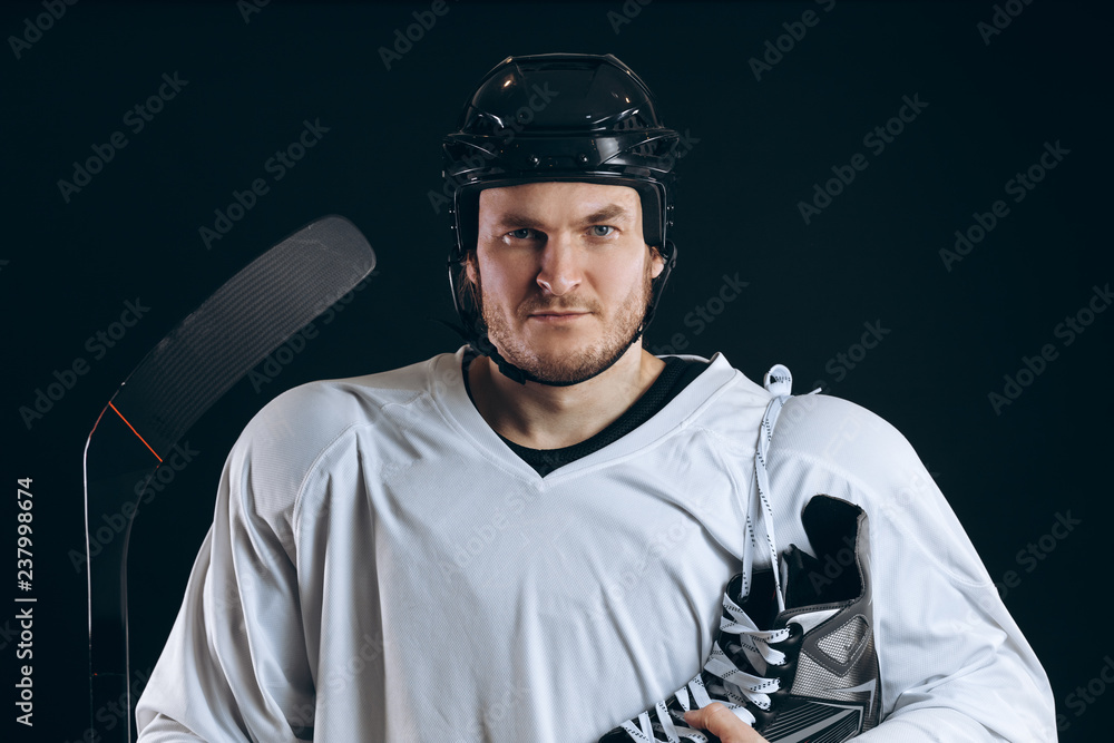 Naklejka premium Emotional hockey player looking at camera skate and gaming stick . Isolated on black