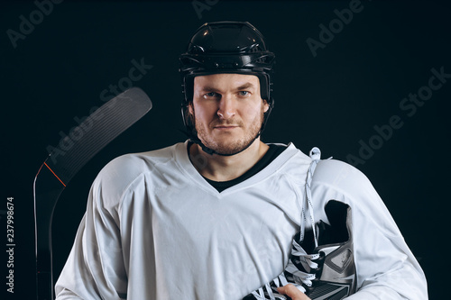 Emotional hockey player looking at camera skate and gaming stick . Isolated on black