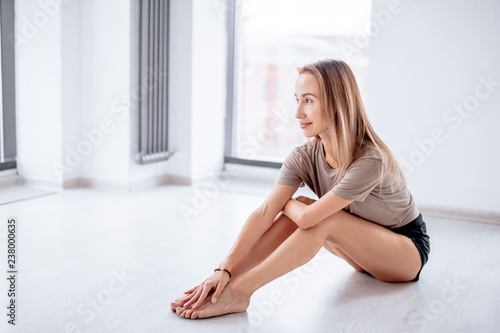 smiling attractive blond girl resting after workout. close up side view photo. relaxation concept. copy space. freedom