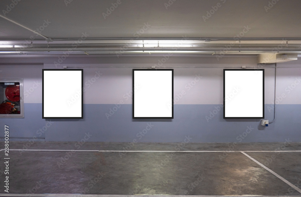 indoor car parking and empty white billboard .Blank space for text and images. indoor car parking and empty white billboard .Blank space for text and images.