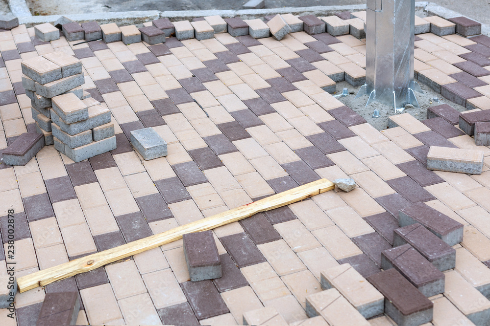 Fototapeta premium New stainless electric pole installation. Concrete stone paving flag. Public pedestrian area renovation. Lamdcaping and renovation of Walkway zone in city park
