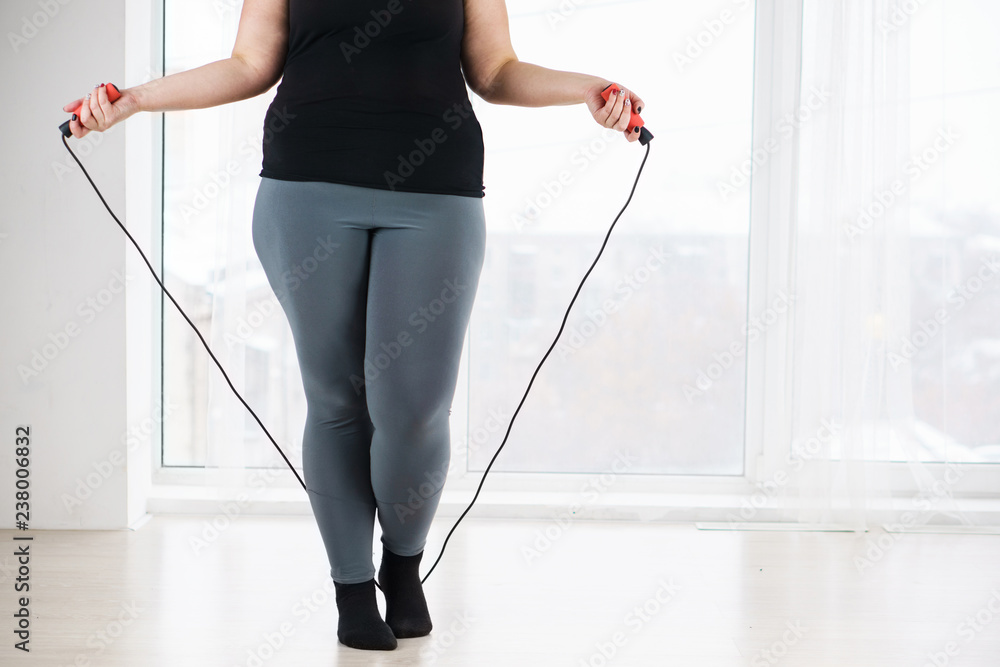 cardio workout, weight loss, endurance, jump-fit, vitality, active lifestyle. overweight woman with jumping rope before workout cardio workout, weight loss, endurance, jump-fit, vitality, active lifestyle. overweight woman with jumping rope before workout