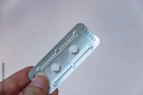 Hand holding an Emergency contraceptive pills on a white background. Picture of hormones tablets to prevent pregnancy photo