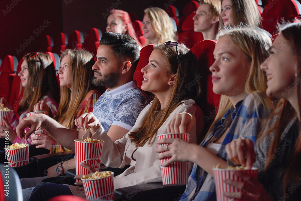Group of female watching comedy in cinema.