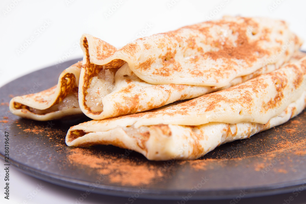 Pancakes stuffed with braised apples sprinkled with cinnamon Pancakes stuffed with braised apples sprinkled with cinnamon
