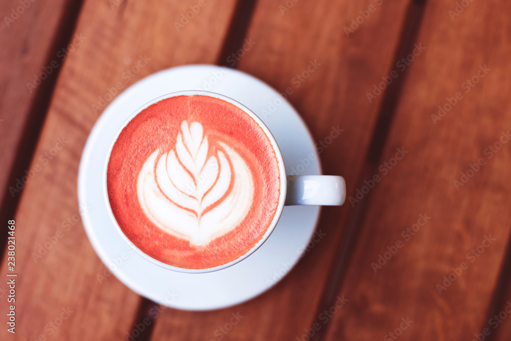 Φωτογραφία A cup of coffe with latte art on wooden table toned in trendy Living Coral color