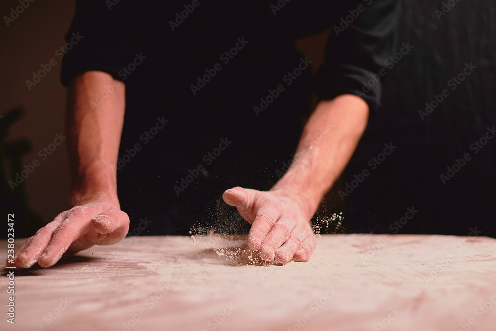 hands kneading dough on table