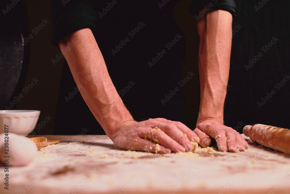 hands of baker kneading dough