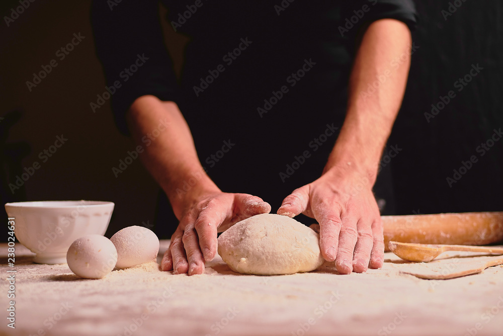 Fototapeta premium woman kneading dough on table