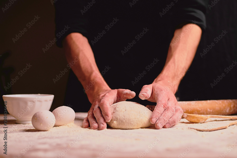 Fototapeta premium woman kneading dough on table