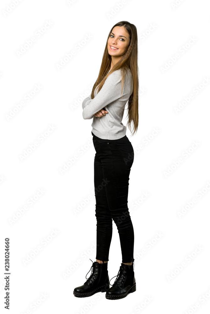 Full-length shot of young girl keeping the arms crossed in lateral position while smiling on isolated white background Full-length shot of young girl keeping the arms crossed in lateral position while smiling on isolated white background