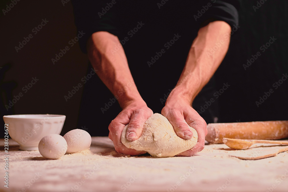 Fototapeta premium hands of baker kneading dough