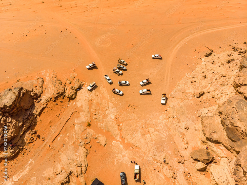 Φωτογραφία Vertical aerial view of a pack of off-road vehicles with tourists in the Wadi Ru