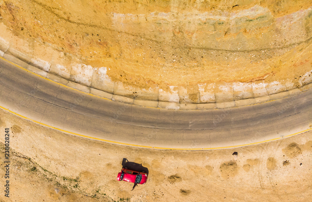 Φωτογραφία Vertical aerial photograph of the cliffs and the road at the Dead Sea in Jordan, with a parked red car