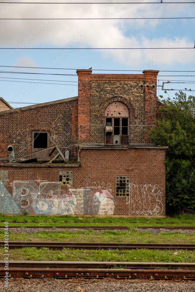 old train station with broken windows and broken roofs.