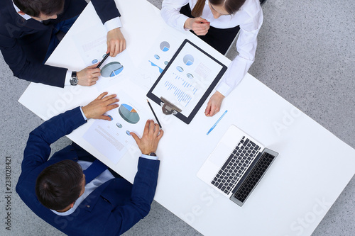 Group of business people analyzing financial documents, view from above. Business team at meeting