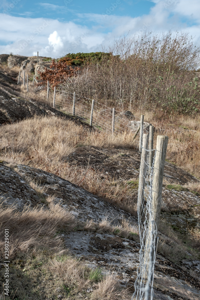 fence with wooden poles and nets on rocks fence with wooden poles and nets on rocks