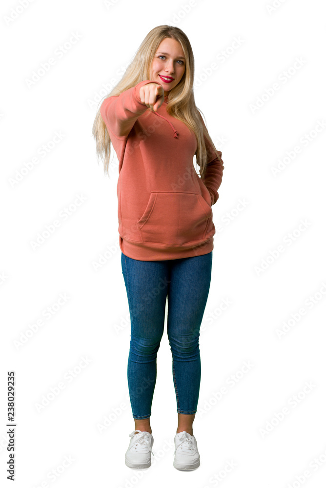 A full-length shot of a Young girl points finger at you with a confident expression on isolated white background A full-length shot of a Young girl points finger at you with a confident expression on isolated white background