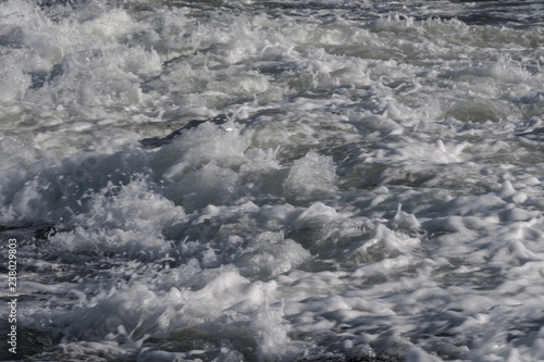 foam from the ocean that comes across the rocks