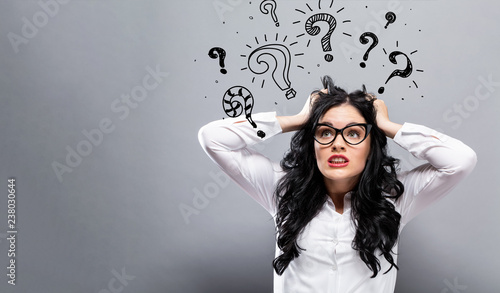 Question marks with young business woman feeling stressed