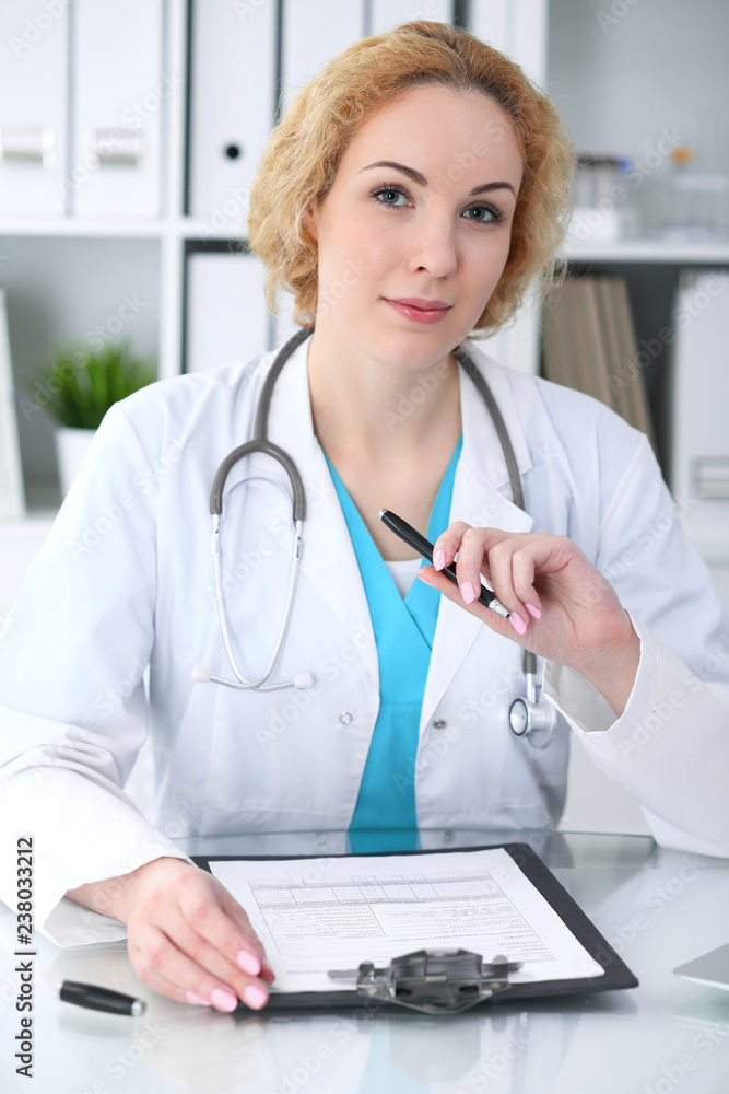 Doctor woman at work. Physician filling up medical history records form at the desk. Medicine, healthcare concept Doctor woman at work. Physician filling up medical history records form at the desk. Medicine, healthcare concept