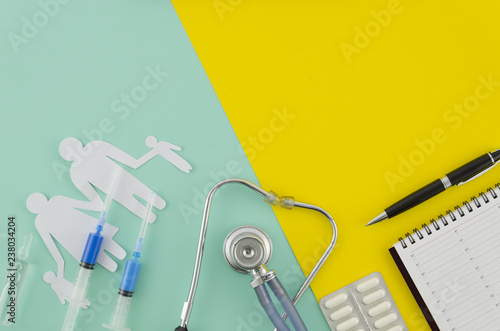 Medical or healthcare concept. Medical apparatus such as stethoscope and spiral blank notepad mock up on blue and yellow duocolor background. Flat lay view. photo