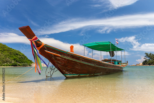 Traditional thai long boat moored at a beach © Olga Lipatova