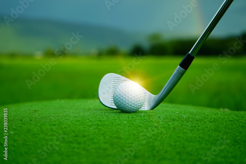 Blurred golf ball and golf club in beautiful golf course at sunset background.