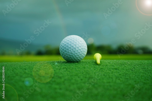 Golf ball on green in beautiful golf course at sunset background.