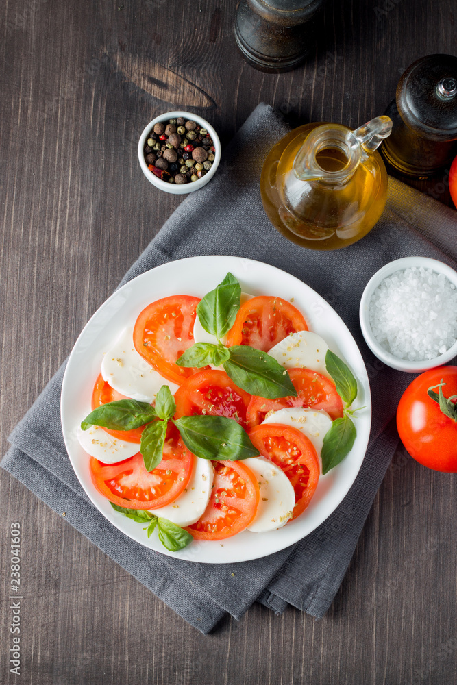 Close-up photo of caprese salad with ripe tomatoes, basil, buffalo mozzarella cheese. Italian and Mediterranean food concept. Fresh and healthy organic meal. Starter and antipasti. Close-up photo of caprese salad with ripe tomatoes, basil, buffalo mozzarella cheese. Italian and Mediterranean food concept. Fresh and healthy organic meal. Starter and antipasti.