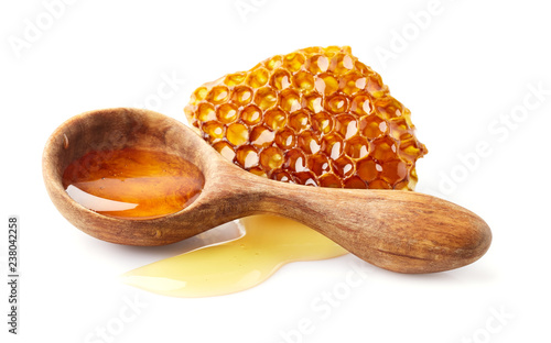 Honey in wooden spoon with honeycomb