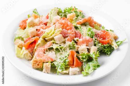 seafood caesar salad with shrimps, croutons, salad leaf, parmesan cheese and salmon