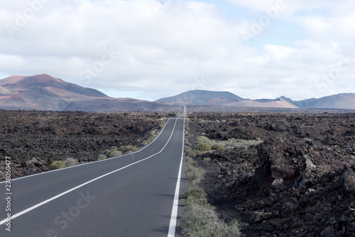 Endless highway through the volcanic landscape. Lanzarote. Canary islands. Spain