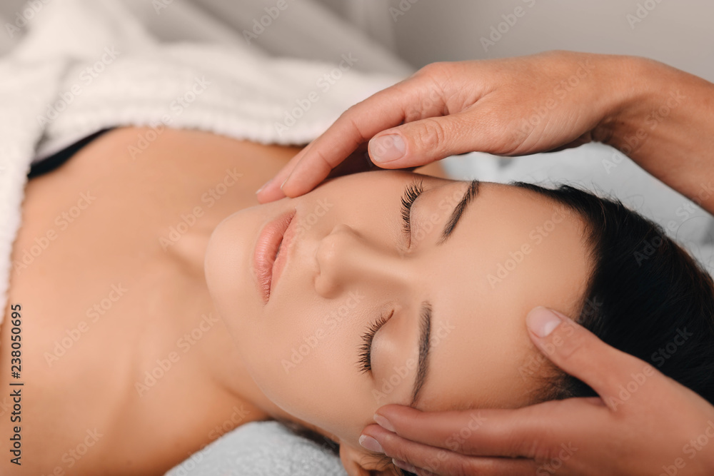 young woman receiving a face massage at the spa