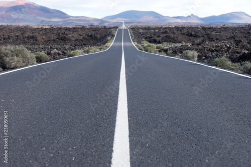 Endless highway through the volcanic landscape. Lanzarote. Canary islands. Spain