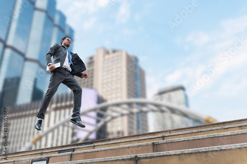 A businessman levitate from the ground with the buildings on the background