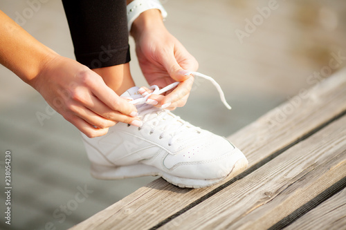 Fitness. Close up female runner is tying her shoelace