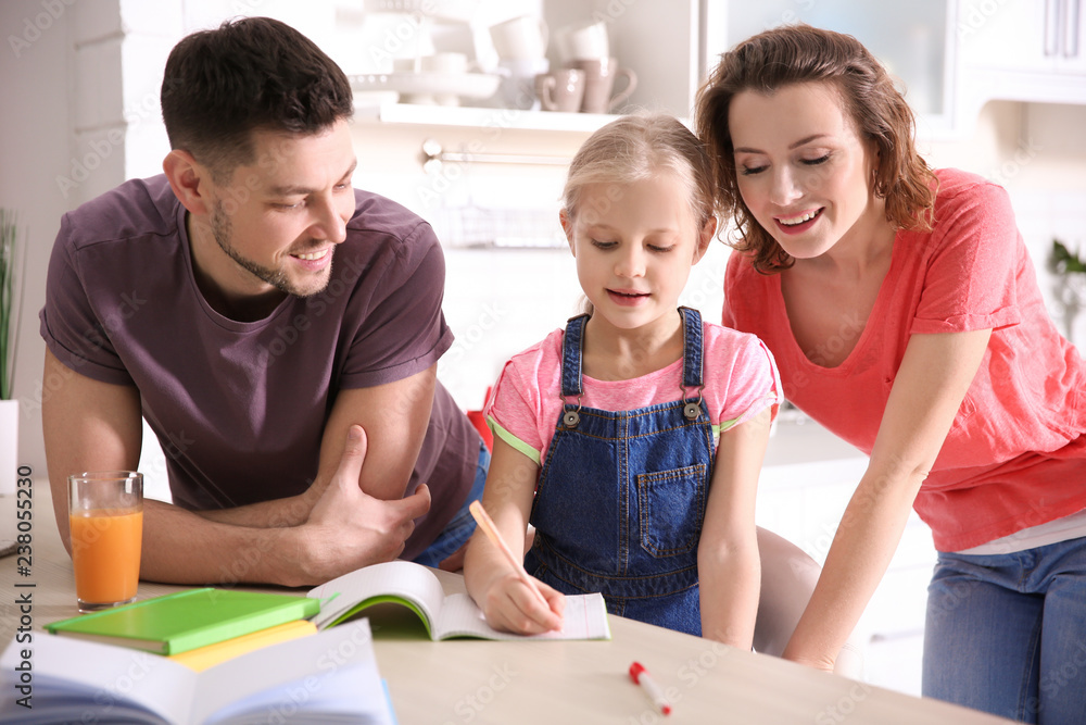 Little girl with parents doing homework at home Little girl with parents doing homework at home