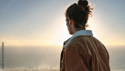 Young man overlooking sea on winter day