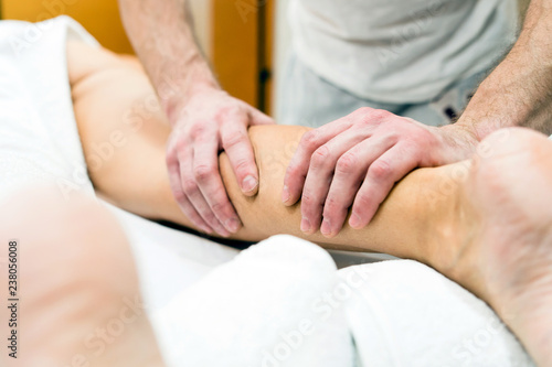 woman getting calves massage in spa salon