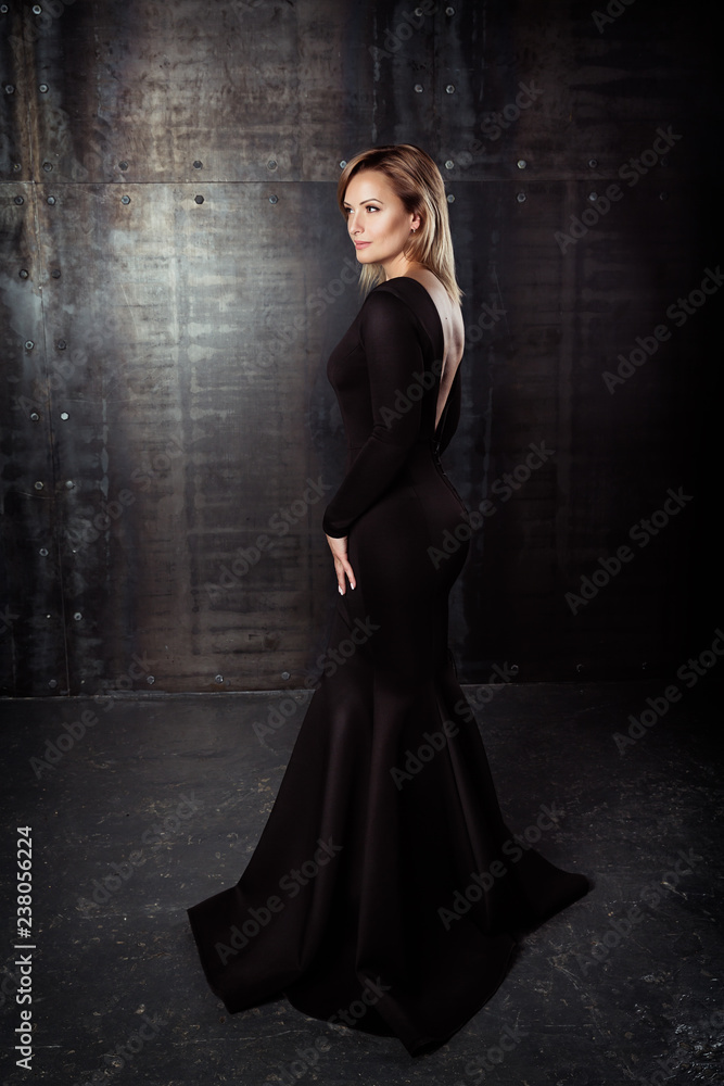 Beautiful model posing in sexy dress at black studio Beautiful model posing in sexy dress at black studio