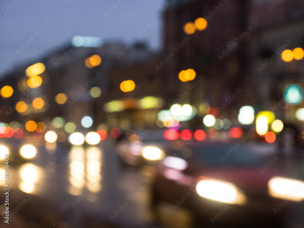the city hallowed night street in the blurred focus on which cars go and multi-colored glare of headlights and lanterns are visible